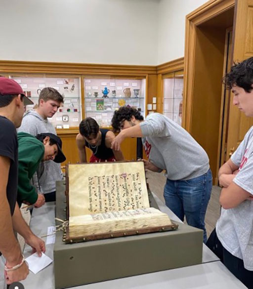 Vincenzo Dimaggio showing manuscripts to Italian students at the Lilly Library