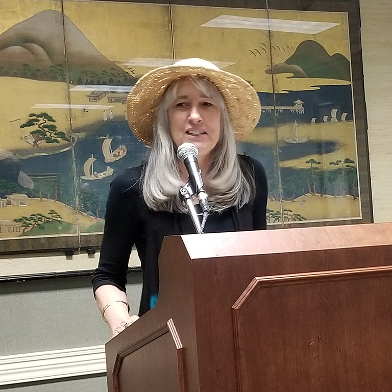 Professor Margot Gray, who speaks at a lectern.