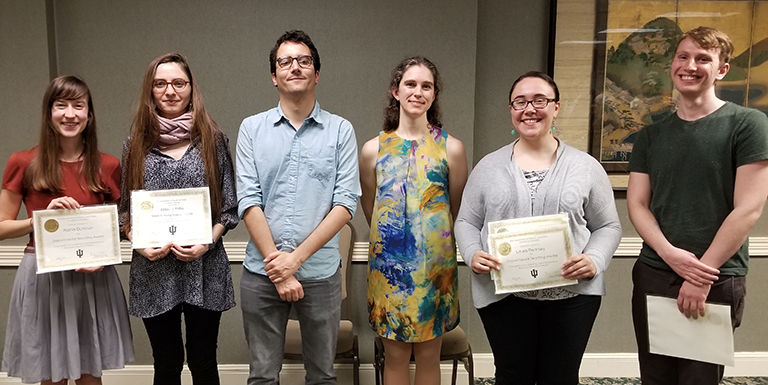 Students pose for photo with awards. 