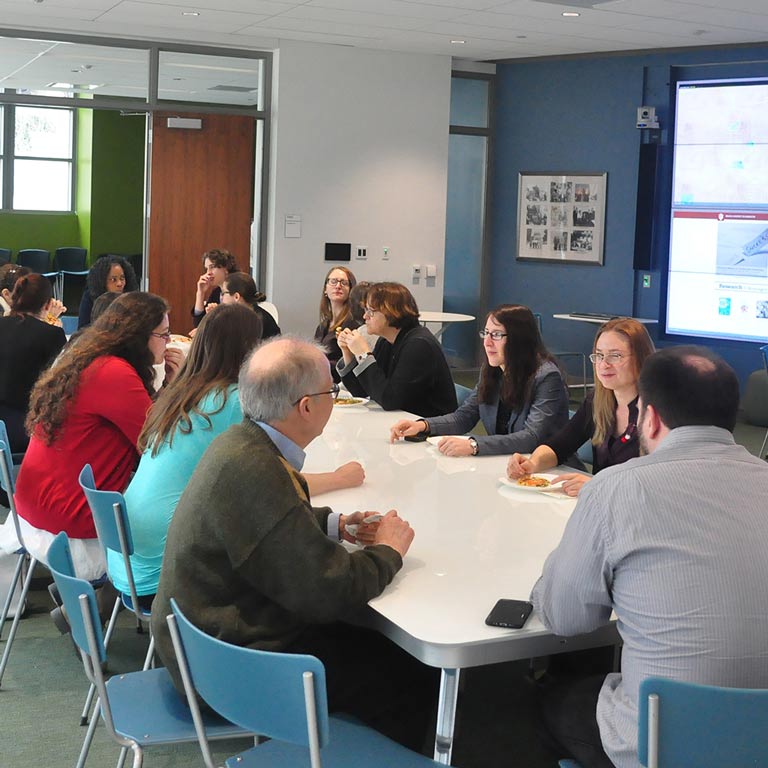 Graduate students gather in a classroom.